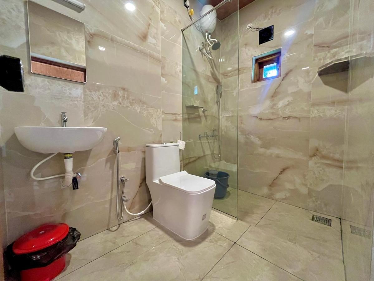Guest bathroom seen wide: basin and mirror beside the glass shower