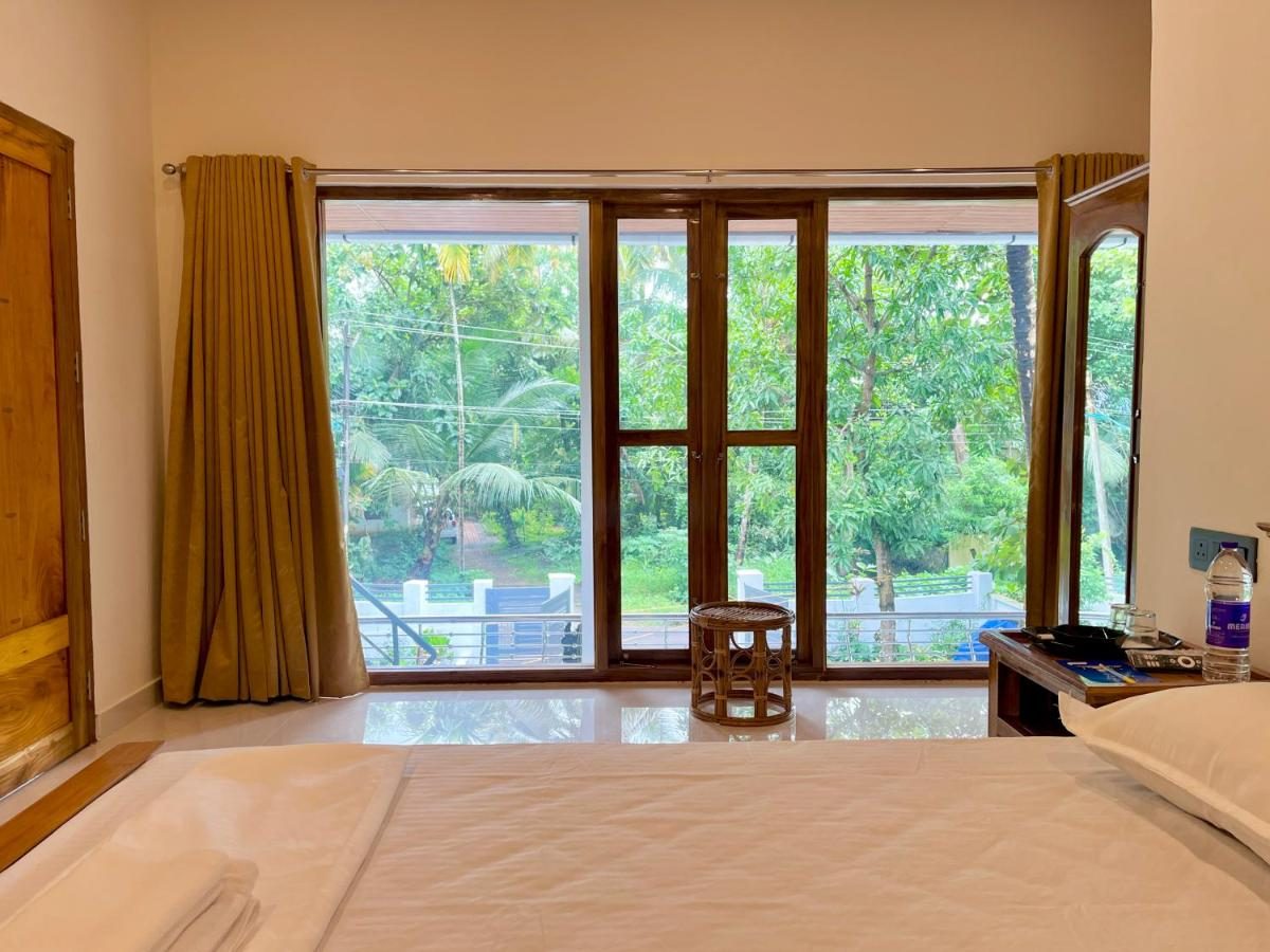 Bedroom looking out through full-height teak-framed French windows