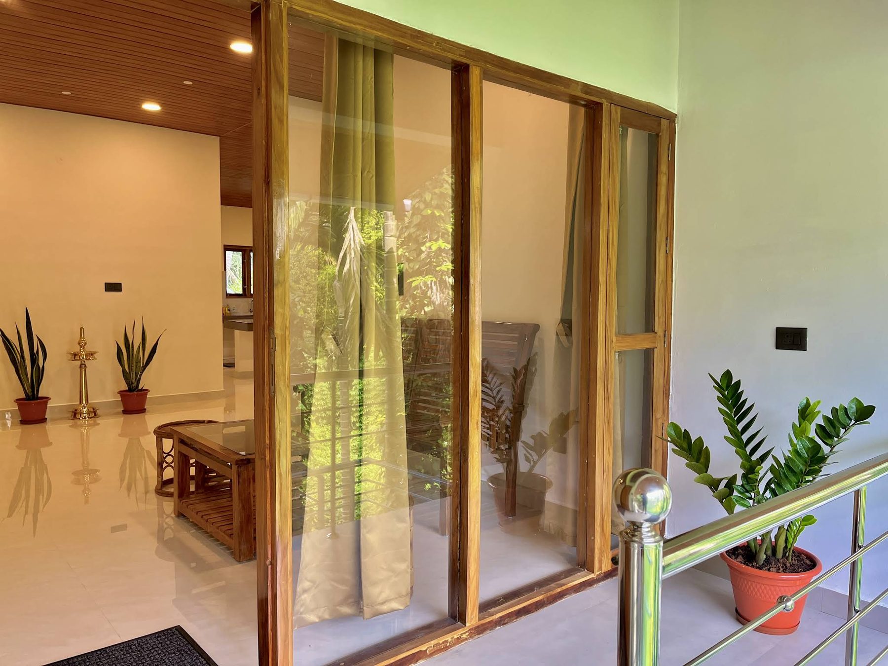 Upper landing seen through a full-height teak-framed glass partition