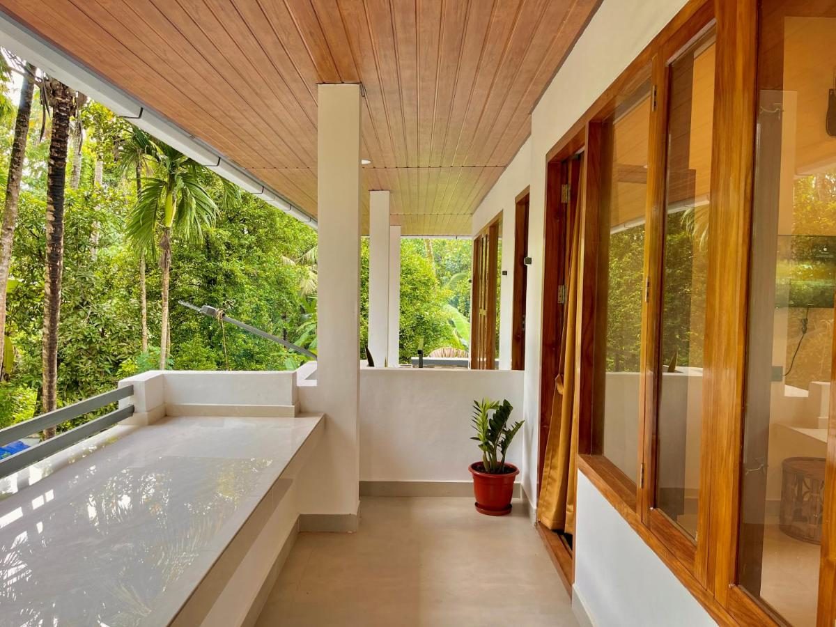 Upper verandah in full daylight, teak-plank soffit above a long white parapet